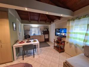 a living room with a table and a kitchen at Semelia's Guest house in Spata