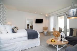 a bedroom with a large bed and a living room at Insula Alba Resort & Spa (Adults Only) in Hersonissos