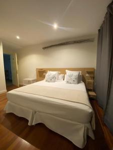 a bedroom with a large bed with white sheets and pillows at Hotel Casa Socotor in Sallent de Gállego