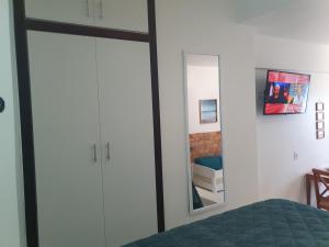 a bedroom with a bed and a mirror at Bahia Flat - Flats na Barra in Salvador