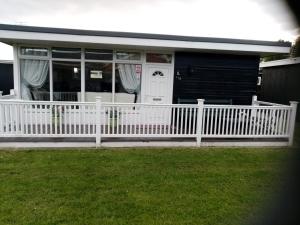 a white fence in front of a house at 116 cherry park in Chapel Saint Leonards