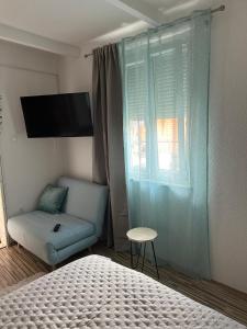 um quarto com uma cama, uma cadeira e uma janela em Old Town Lucky Star Apartments Split em Split