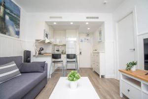 sala de estar con sofá y cocina en Ocean House Bloque 3 Planta 1 By IVI Real Estate, en Torremolinos