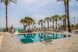 una piscina con palmeras y el océano en Ocean House Bloque 3 Planta 1 By IVI Real Estate, en Torremolinos