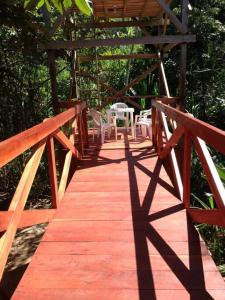 - un pont en bois avec des chaises et une table dans l'établissement Rustic Cabin - Tambopata Natural Reserve, à Puerto Maldonado