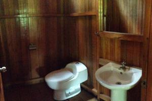 ein Badezimmer mit einem weißen Waschbecken und einem WC in der Unterkunft Rustic Cabin - Tambopata Natural Reserve in Puerto Maldonado