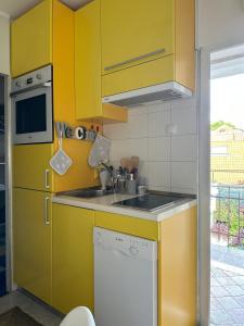 uma cozinha com armários amarelos e um lavatório em Old Town Lucky Star Apartments Split em Split