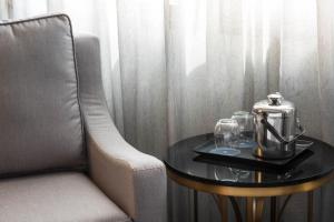 a coffee table with a tea kettle and glasses on it at Sheraton Eatontown Hotel in Eatontown