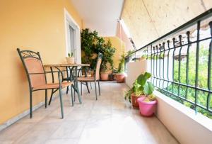 a balcony with a table and chairs and plants at Lili's Apartment in Elefsina