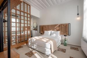 Un dormitorio con una cama blanca y una ventana grande. en On Luxury Chania, en La Canea