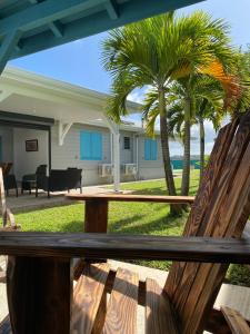 a wooden bench sitting on a porch with palm trees at VOIR com 5 étoiles airb, Villa Zolenzo, la tête dans les montagnes, 10 pers in Petit-Bourg