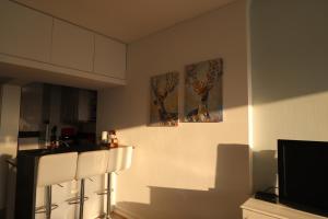 eine Küche mit zwei Bildern an der Wand und einem TV in der Unterkunft Rua das Arcadas do Parque 52 in Estoril