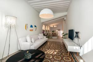 Una sala de estar con un sofá blanco y una mesa. en On Luxury Chania, en La Canea