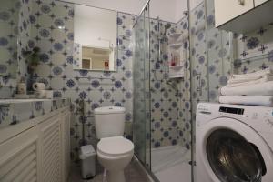a bathroom with a toilet and a washing machine at Rua das Arcadas do Parque 52 in Estoril