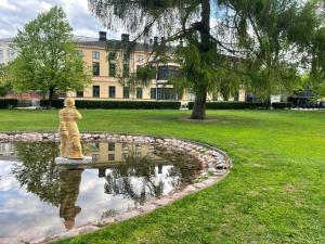 a statue in a pond in front of a building at Sea, Sauna and City Center in Helsinki