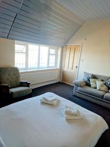 a room with a bed and two chairs and a couch at Poachers Pocket Seaview in Bacton