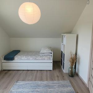 シュヴェントイにあるSunnyHouse Sventojiの小さなベッドルーム(ベッド1台、ランプ付)