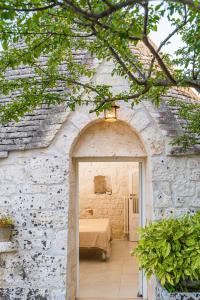ロコロトンドにあるTrulli Francesca Cicloviaの石造りの建物の寝室につながるアーチ道
