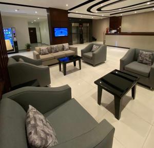 a living room with couches and a table and a tv at أجنحة الطائف - اقتصادي in Taif