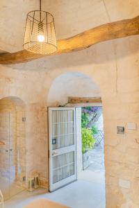 ロコロトンドにあるTrulli Francesca Cicloviaの石壁の扉付きの部屋