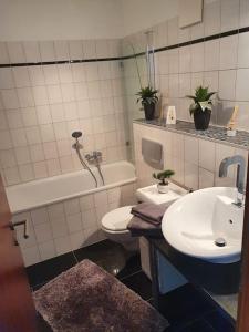 Zentrale Messe/Ferien Whg mit Garten & Parkplatz في راتينغن: حمام مع حوض ومرحاض وحوض استحمام