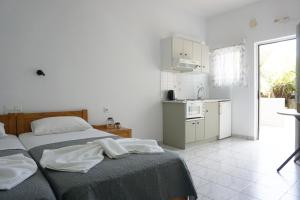 um quarto com 2 camas e uma cozinha em Aphrodite Studios & Apartment em Balíon