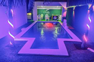 una piscina en una habitación con luces moradas en Villa De Cruz - Groovy Suite en Scarborough