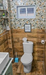 een badkamer met een toilet, een wastafel en een raam bij Villa De Cruz - Groovy Suite in Scarborough