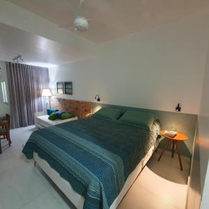 a bedroom with a large bed and a couch at Bahia Flat - Flats na Barra in Salvador