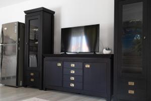 a black cabinet with a television on top of it at Holidays Summer Vibes Apart Mamaia Nord in Năvodari