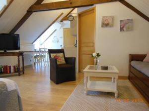 a living room with a couch and a table at Les Hortensias de Kerbarch in Ploemel