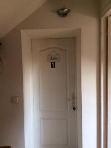 eine weiße Tür in einem Zimmer mit einem Licht darüber in der Unterkunft ÉTAGES PRIVÉE POUR 4 PERSONNES 2 CHAMBRES ET 1 SALE DE BAIN i in Roissy-en-France