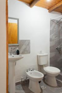 y baño con lavabo, aseo y espejo. en Monoambiente Colibrí en Capilla del Monte