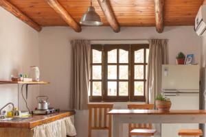 cocina con mesa, nevera y ventana en Monoambiente Colibrí en Capilla del Monte