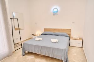 een slaapkamer met een bed met twee handdoeken erop bij Conchiglia & Medusa Home Otranto in Otranto