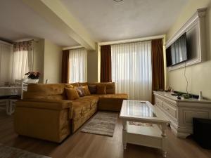 una sala de estar con un sofá y una mesa en Apartament Rose, en Gura Humorului