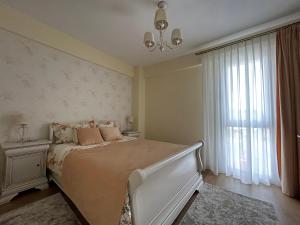 sypialnia z łóżkiem i oknem w obiekcie Apartament Rose w mieście Gura Humorului