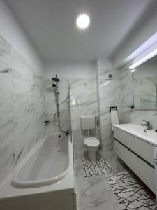 a bathroom with a tub and a toilet and a sink at Apartament Rose in Gura Humorului