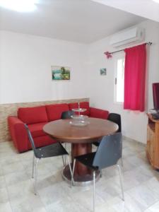 een woonkamer met een tafel en een rode bank bij Eureka 133 in Costa Del Silencio +15 foto's