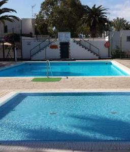 een groot blauw zwembad naast een gebouw bij Eureka 133 in Costa Del Silencio