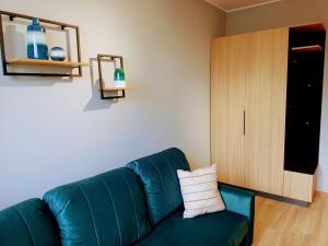 a living room with a green couch and a cabinet at Apartament przy dworcu in Gdańsk