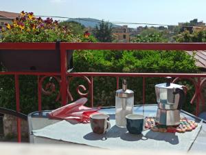 a table with two coffee makers and cups on a balcony at B&B In Sella in Vico Equense