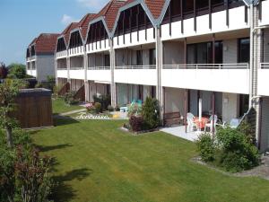 un edificio de apartamentos con césped delante en Christa & Wilfried Lammermann, en Hooksiel