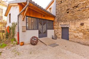 a brick building with a door and a wooden porch at Holiday Loft 58 in Arbois