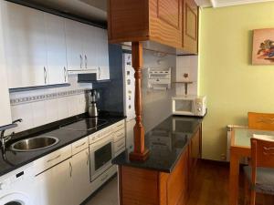 a kitchen with white cabinets and a sink and a microwave at Bella Vista in Ramales de la Victoria +3 photos