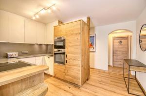 a kitchen with a large wooden cabinet in a room at Apartment Antonia - by Alpen Apartments in Zell am See