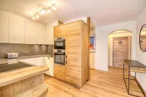 una cocina con un gran armario de madera en una habitación en Apartment Antonia - by Alpen Apartments, en Zell am See