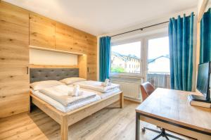 a bedroom with two beds and a large window at Apartment Antonia - by Alpen Apartments in Zell am See