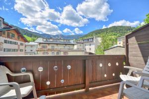 a balcony with chairs and a view of a city at Apartment Antonia - by Alpen Apartments in Zell am See