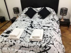 1 cama blanca y negra con 2 almohadas en Departamento en Palermo Parking included en Buenos Aires